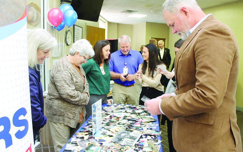 Staff members of Savoy Medical Center look through photographs depicting the hospital’s 75-year history during a celebration held Tuesday, December 16. Among those pictured are Chief Nursing Officer Laurie Manuel, Director of Hospital Operations Danny LaHaye, and Chief Executive Officer Brian Denton. (Gazette photo by Kathy Longino)