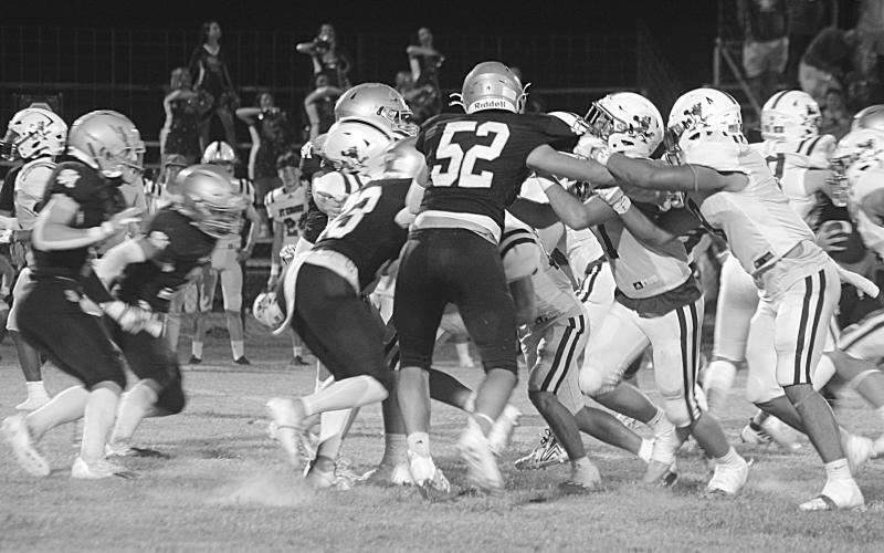 The Trojan defense led by Dane LeJeune (52) combines to make a stop against the St. Edmund offense. (Gazette photo by Tony Marks)