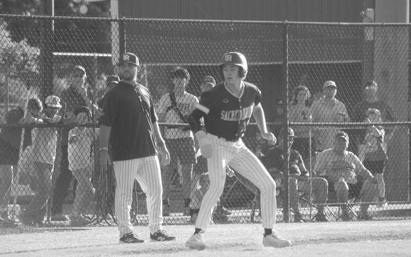 Sully Manuel (13) eyes home plate as he takes his lead off the third base bag during Sacred Heart’s 3-2 playoff loss to St. Edmund on Sunday, May 3. (Gazette photo by Tony Marks)