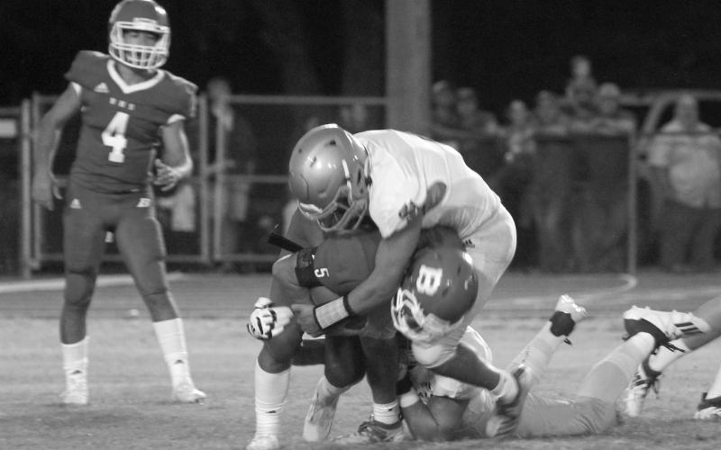 The Sacred Heart Trojan defense swarms over Basile High running back Ethan Bazinet (5) before he can gain any positive yardage. The Trojans throttled the Bearcat offense the entire game last season, holding Basile to 18 total yards in a 28-0 win. (Gazette file photo)
