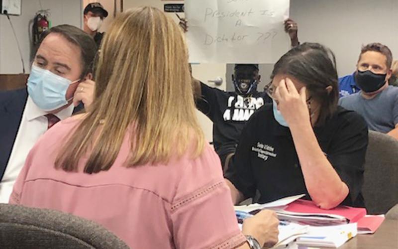 Arthur Sampson is pictured holding a poster at Wednesday’s meeting of the Evangeline Parish School Board. The poster reads “Evangeline Parish School Board President Is A Dictator???” It is in response to the board not allowing Sampson to speak at the last meeting. (Gazette photo by Tony Marks)