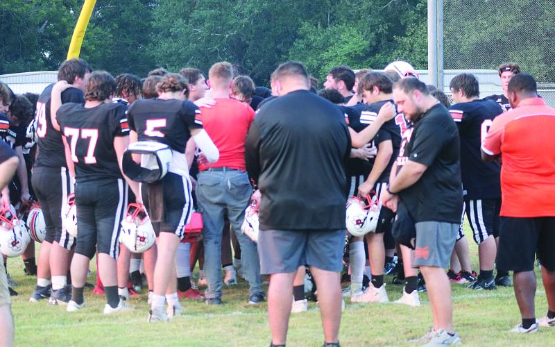 The Pine Prairie Panthers have a moment of prayer after a scrimmage against the Basile Bearcats on Thursday, August 22. Pictured in the front are head coach Lance Meyers (left) and assistant coach Hunter David (right). (Gazette photo by Tony Marks)