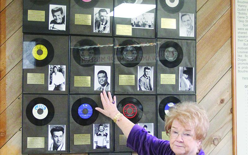 Sharon Fontenot is pictured as she points out the 13 Swamp Pop records which were Billboard and Cashbox chart hits of the 1950s and 1960s. By comparison, Cajun music had two songs to hit the charts, while Zydeco had one song to make the charts. (Gazette photo by Tony Marks)