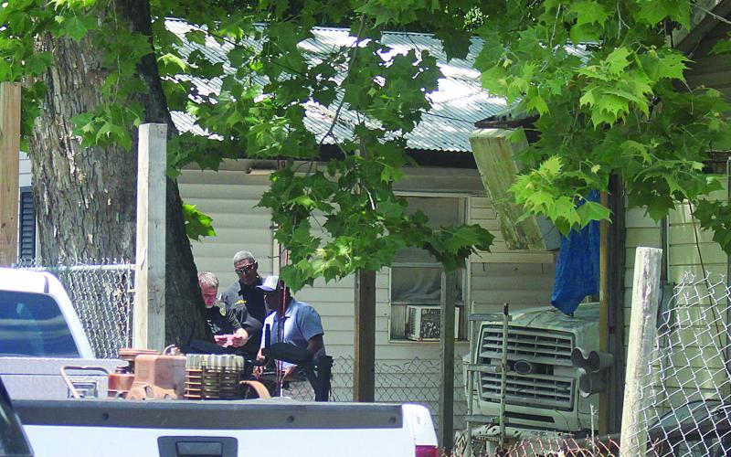 Ville Platte Chief of Police A. Perry Thomas (center) and other law enforcement officers investigate evidence collected at the scene of a fatal shooting in Ville Platte on Monday, May 4. (Gazette photo by Tony Marks)