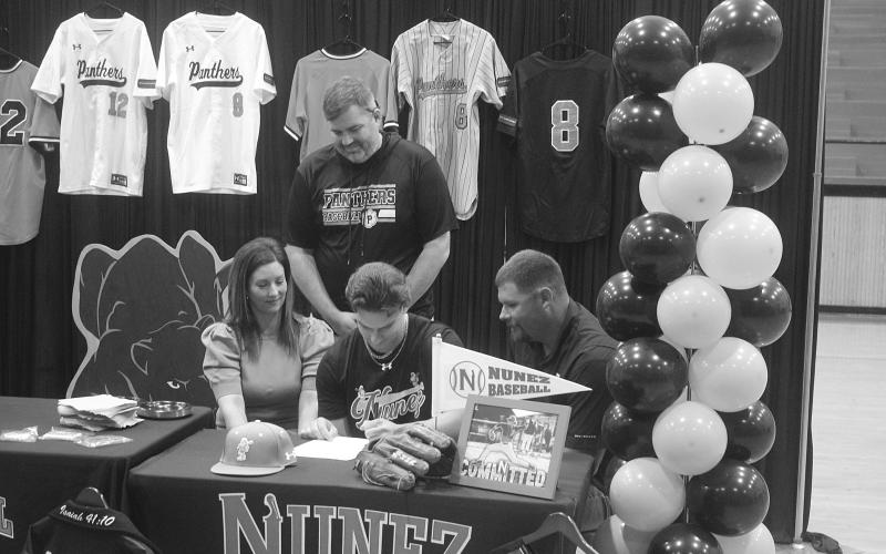 Tanner McCollough (center), of Pine Prairie High School, is pictured as he signs to play baseball at Nunez Community College. Pictured on the left is his mother, Allison, and on the right is his father, Tony. (Gazette photo by Tony Marks)