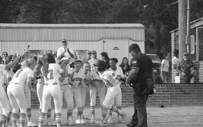 Josie Vidrine (12) celebrates at home plate with her Pine Prairie teammates after delivering a game-tying home run against South Beauregard on Monday. (Gazette photo by Tony Marks)