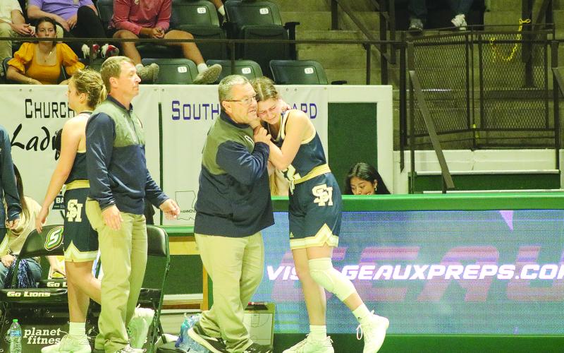 Sacred Heart girls’ basketball head coach Craig Whittington (left) consoles senior player Kali Shiver (right) as she exits the state semifinal game against Southern Lab. (Gazette photo by Tony Marks)