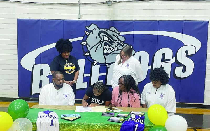 Destiny Lavigne (seated center left) is pictured as she signs to play college softball with Xavier University of Louisiana. Also pictured (from left) are standing Ville Platte High School Principal Shelsy Williams and former Ville Platte High School Assistant Principal Dawn Bellard; seated- Ville Platte High School Softball Coach Devinskie Arvie, Latoya Lavigne, and Ville Platte High School Assistant Coach Shonda Jack. (File photo)