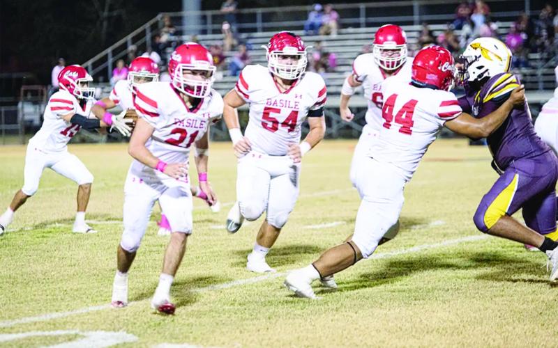 Pierre Berzas (54), Scott Berzas (60), and Da’Shawn Randall (44) pave the way for the Basile offense against an Elton defender.