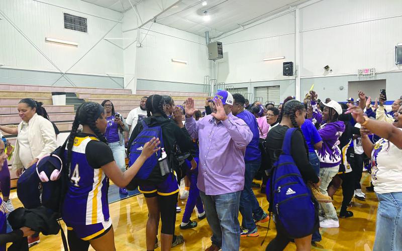 Ville Platte Mayor Ryan LeDay Williams (center) greets Donashia Jack (14) on the court after the 5th seed Ville Platte Lady Bulldogs pulled off an upset against 4th seed Springfield in the quarterfinals. With the win, Ville Platte advanced to the girls’ basketball state semifinals. (Gazette photo by Tony Marks)
