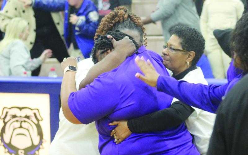 Ville Platte Lady Bulldogs’ head coach Rhonda Thomas (center) celebrates with her mother, City Councilwoman Anna Frank, (right) and other supporters after her team defeated Springfield, 52-46. (Gazette photo by Tony Marks)