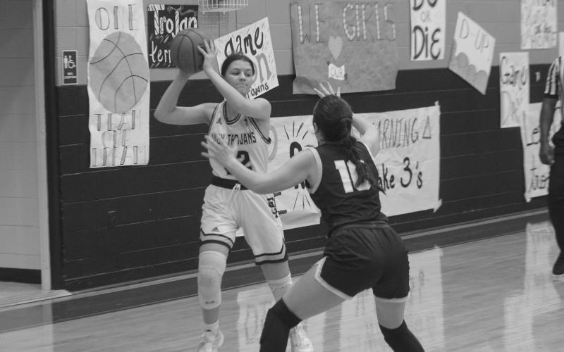 Kali Shiver (22) looks to pass the ball to a Sacred Heart teammate while being guarded by a St. John defender.
