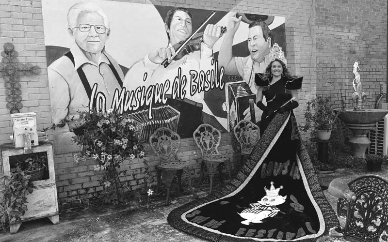 Abigail Fruge, the reigning La. Swine Festival Queen, poses in her full regalia at the Music of Basile mural in old downtown.