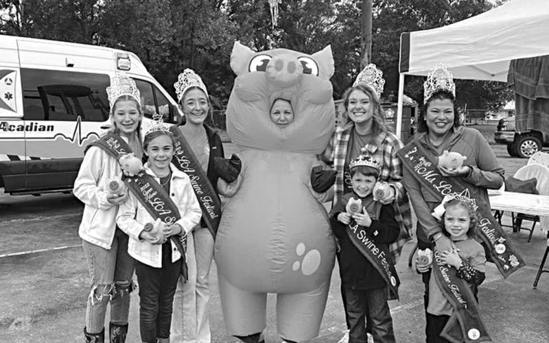 SWINE FESTIVAL ROYALTY ENJOYING LAST YEAR’S EVENT - (from left) Ava Manuel, Mallory Ortego, Bailey Stelly, Champion Hog Caller Jackie Ravey in the pig costume, Abigail Fruge, Carson Johnson, Vanessa Lastrapes, and Skyla McElfresh.