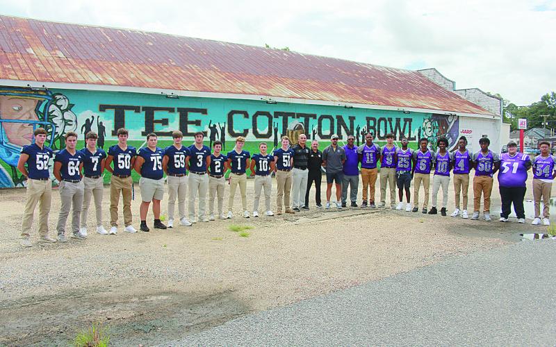 From left are Trojan seniors, Campbell Earles, Everett Johnson, Hayden Droddy, Tucker Chesne, Collin Estilette, Max Hamlin, Briggs Ardoin, Bradley Fusilier, Gabe Wilmouth, Blake Hebert, and Gabe Fontenot; assistant coaches, Daniel Scully and JP Boullion; head coach, Josh Harper; and Bulldog head coach Roy Serie; and seniors, Christian Aclis, Bastian Veillon, Charles Jason, Jakahalan Slaughter, Omarion Frank, Adonis Thomas, Troas Murray, Austin Fontenot, and Allyus Dick. (Gazette photo by Tony Marks)