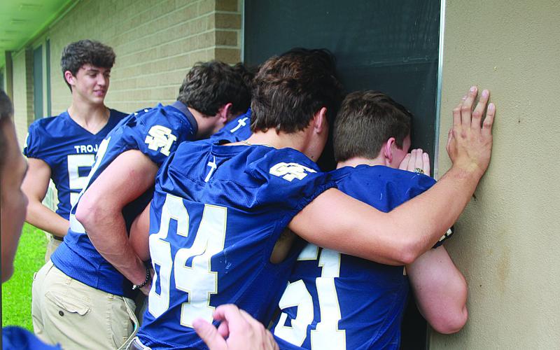 Several Sacred Heart seniors peer through the hospital window of Tim Fontenot to send him encouragement while in recover at Mercy Regional Medical Center. The seniors from Ville Platte High also visited. (Gazette photo by Tony Marks)