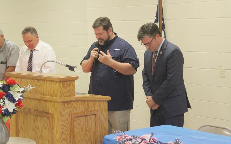 Pastor Kevin West (center) leads the opening prayer. (Gazette photos by Tony Marks)