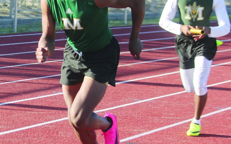 Mamou’s Keshawn Guillory (front) and Kevin Jason (back) participate in a relay race during the track meet held Tuesday, March 26, at Pine Prairie. (Gazette photo by Rhett Manuel)