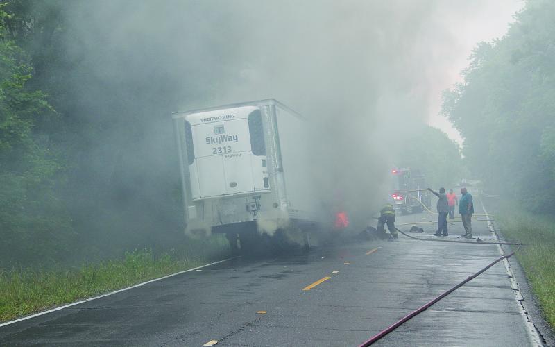 Pictured are firefighters as they battle to contain a truck fire on the Whiteville Road on Tuesday, May 3. What caused the refrigerated trailer to be engulfed in flames was not known as of press time.  (Gazette photo by Tony Marks)