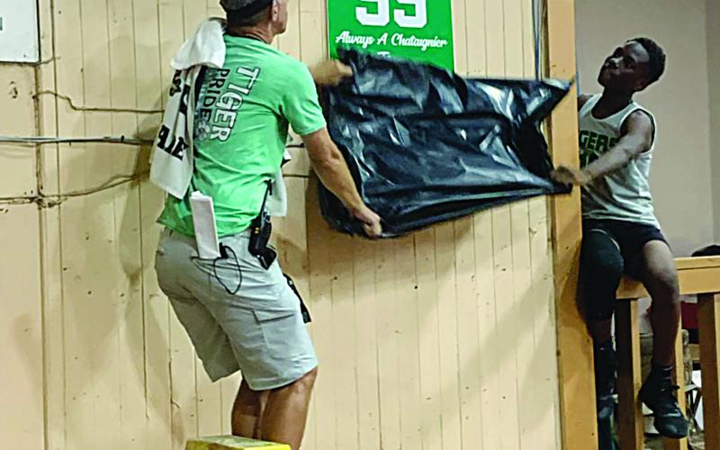 Chataignier Elementary basketball coach Duncan Johnston (left) and Zion Thomas (right) unveil Ty Ardoin’s retired number 55 jersey. (Gazette photo by Rhett Manuel)