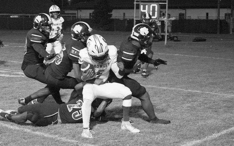 Members of the Ville Platte defensive team swarm to make a stop against a Crowley rusher in the Bulldogs’ 13-12 win on homecoming night to begin district play. (LSN photo by Chuck Sexton)