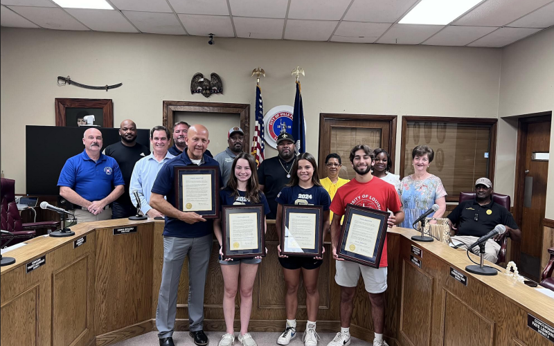Pictured from left are: back row- City Councilmen Bryant Riggs and Tracey Jagneaux; middle row- Fire Chief Chris Soileau, City Clerk Donald Bergeron, City Councilman Shawn Roy, Mayor Ryan LeDay Williams, City Councilwomen Anna Frank, Christine Sam, and Faye Lemoine, and Police Chief Al Perry Thomas (seated); front row- Sacred Heart powerlifting coach Duane Urbina, and Sacred Heart powerlifters Madeline Fusilier, Adeline Launey, and Jesse Johnson. (Gazette photo by Nancy Duplechain)