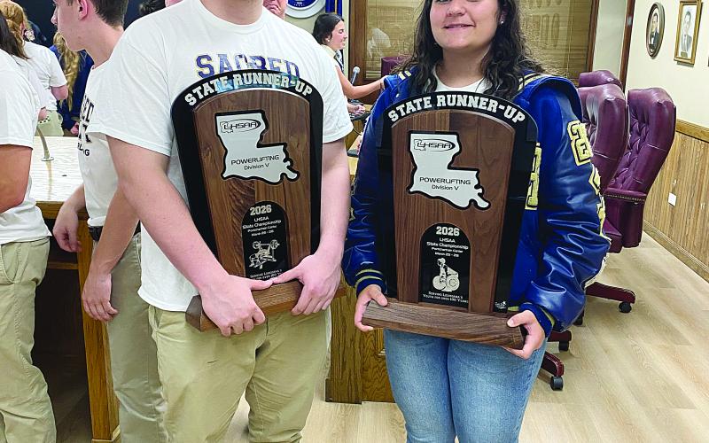 Sam LaFleur (left) and Haylee Dupre (right) are pictured as they display the state runner-up trophies in powerlifting. Both are senior captains for this year’s Sacred Heart teams. (Photo courtesy of Misty Parker)