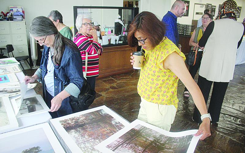 Prints and etchings were available for purchase, with all proceeds being donated to the Evangeline Arts Council for children’s art programs. Mike Perron (left photo) and Sarahi Sawtelle (right photo) are pictured as they browse some of the prints that were available. (Gazette photos by Tony Marks)