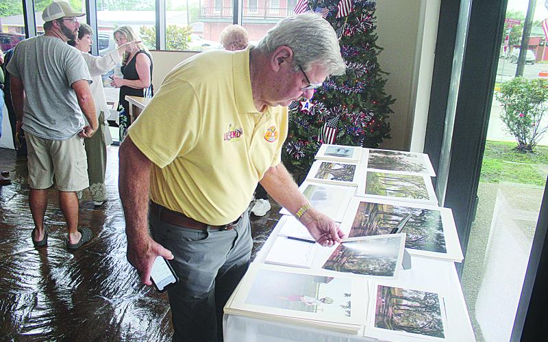 Prints and etchings were available for purchase, with all proceeds being donated to the Evangeline Arts Council for children’s art programs. Mike Perron (left photo) and Sarahi Sawtelle (right photo) are pictured as they browse some of the prints that were available. (Gazette photos by Tony Marks)