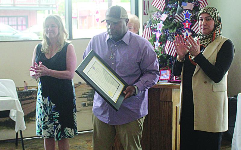 Mayor Ryan LeDay Williams (center) presents a proclamation to Boone’s daughters Carmen Bellard-Foutch (left) and Rachel Escamilla (right).