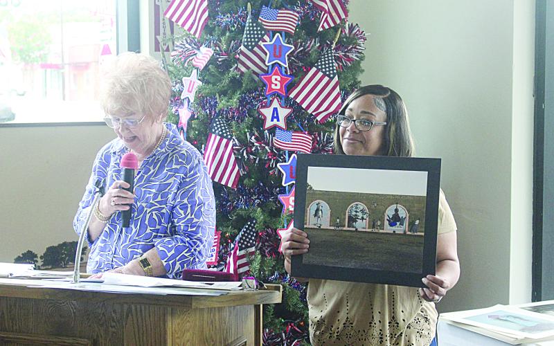 Sharon Fontenot (left) and Candace Dominick (right) display a renderings of Boone’s murals which was painted for the city. (Gazette photos by Tony Marks)