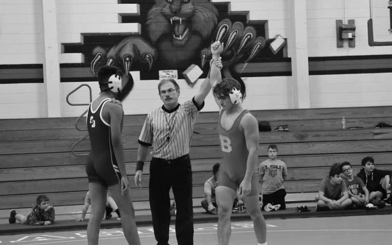 Andre Johnson is declared the winner at 138 pounds.  He was a state runnerup last year, and although a football player, was one of the few pigskin team members to wear a singlet in the opening wrestling action last week. (Photo provided)
