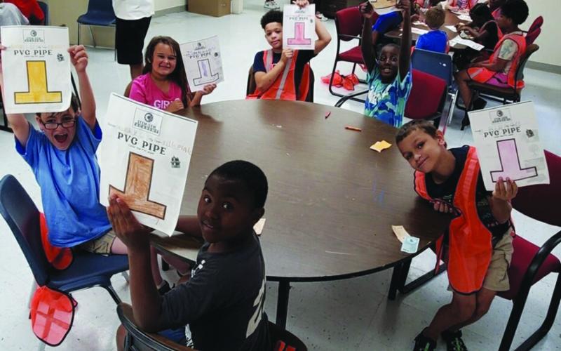 The students show off their artwork and actively engage with the instructor. (Photos courtesy of Jimmy Jones)