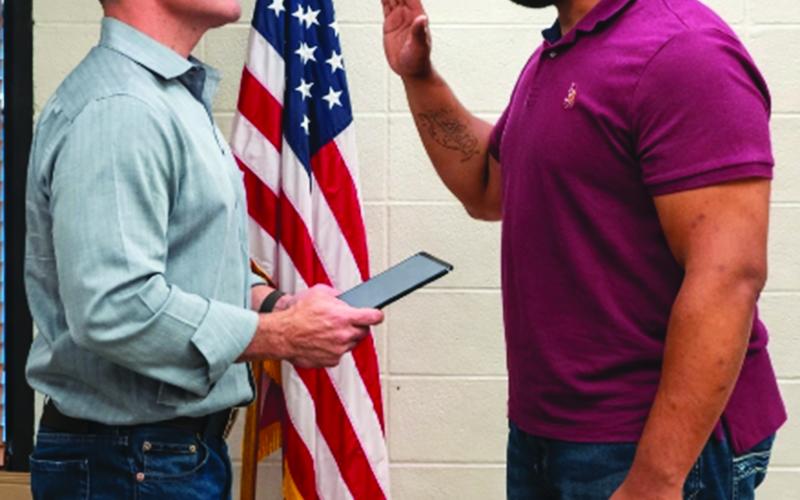 INTERIM POLICE CHIEF TAKES OATH - Nicholas Richardson (right) takes the oath of office for the position of interim police chief for the Town of Basile. Dave Johnson, town attorney and magistrate judge, is shown administering the oath following the Feb. 18 special meeting of the mayor and council. (LSN photo by Darrel LeJeune)