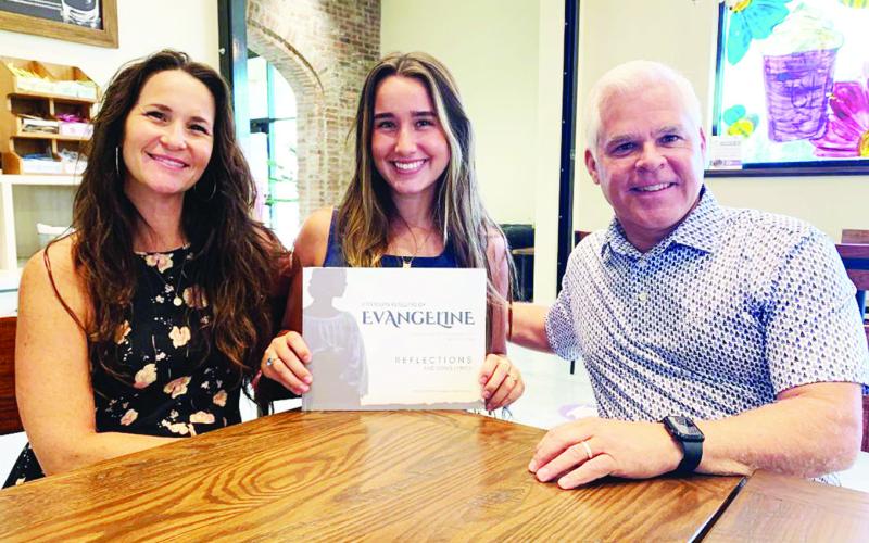 Holding the book “A Modern Retelling of Evangeline” is Lucy Simon (middle), who sang six of the 19 songs. Also in the photo are Lucy’s mom, Michelle, and Jared Bourque, the father of Fr. John Joseph Bourque.