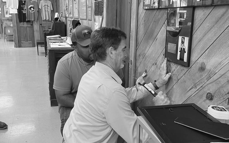 In the bottom right photo, Williams, in back, and Bergeron help hang the new exhibit in the Swamp Pop Museum on Tuesday, September 19. (Gazette photos by Heather Bogard)
