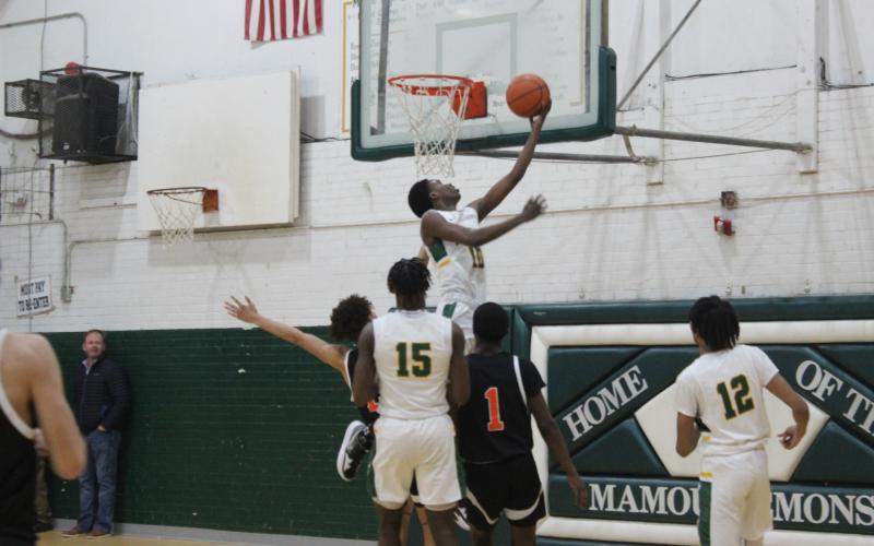 Tyrion Broussard (10) elevates himself over a pair of Pine Prairie defenders. Gazette photo by Rhett Manuel