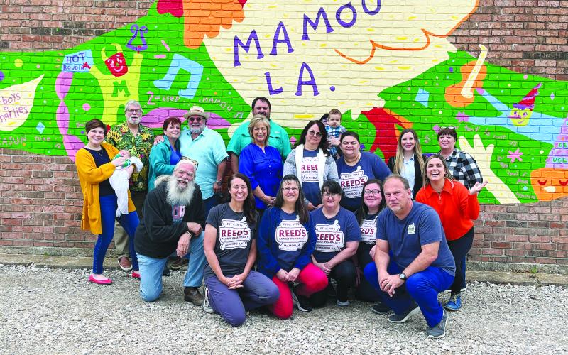 Local artist unveils Mamou mural located on Reed’s Pharmacy building