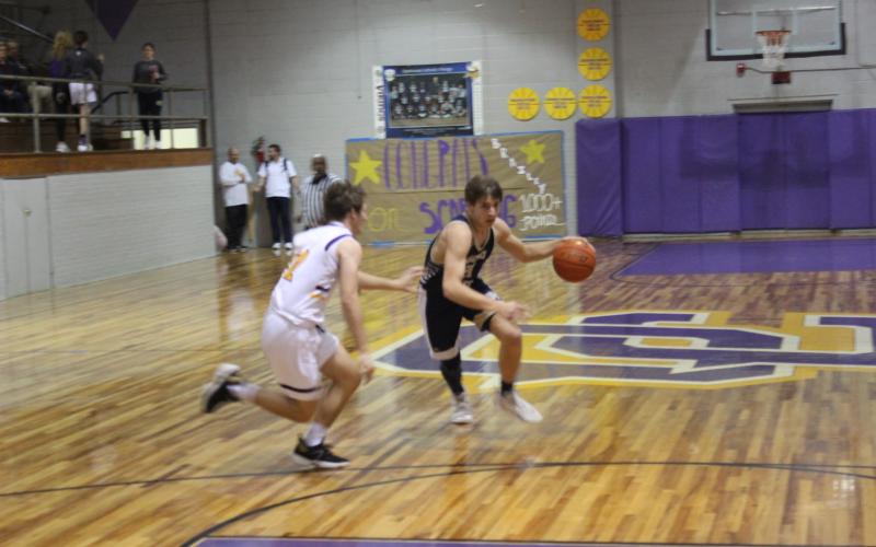 Austin Darbonne (21) fights his way toward the basket in Sacred Heart’s road loss to Opelousas Catholic. (Gazette photo by Rhett Manuel)
