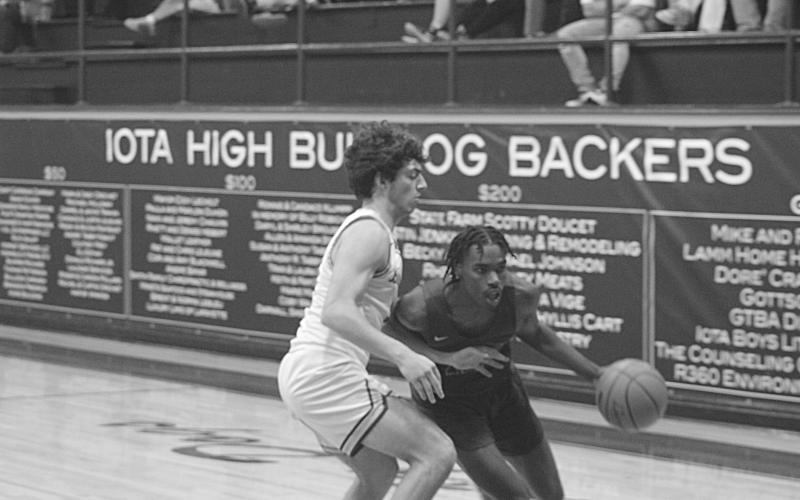Mamou’s Tyrian Broussard (right) looks for points against the Iota Bulldogs Thursday night.  The Green Demons will now close out the regular season on Tuesday, February 14, at home against Pine Prairie, and on Thursday, February 16, on the road at Northwest. (Gazette photo by Rhett Manuel)
