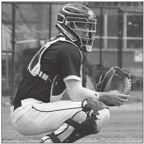 Sacred Heart starting back stop Alex McElwee is pictured as he waits on a sign from the Trojan dugout during a game played this season. (Photo by Lia Launey)