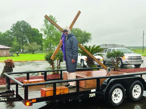 Reverend Matthew Alfred Jr., moderator of the Eastern Seventh District Association, carries the cross as the motorcade departs from Mt. Pilgrim Baptist Church, on Pine Point Road. The event, on Good Friday, culminated with meditations on the Last Seven Sayings. (Gazette photo by Tony Marks)