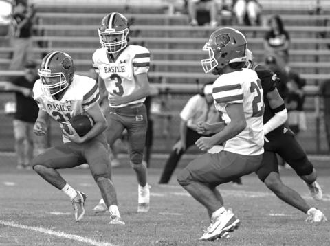Basile High’s Kye Smith (21) puts the ball into play against Sacred Heart with teammates Sayg Smith (3) and Logan Bergeron (22) by his side. (Photo by Tonya Ortego)