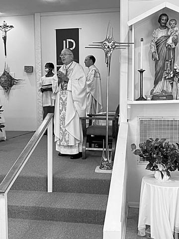 Bishop Douglas Deshotel sings along with The Gloria during the 75th Anniversary Mass of St. Joseph Church in Ville Platte. Pictured in the back is the church’s pastor, Fr. Tom Voorhies. (Gazette photo by Tony Marks)