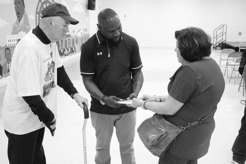 Suzy Fontenot (right) presents new Ville Platte High School head football coach Chris Bland (center) with a copy of Sharpened Iron: The Tee Cotton Bowl Story. Pictured on the left is Tee Cotton Bowl co-founder Tim Fontenot. (Gazette photo by Tony Marks)