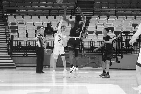 Hayden Deshotel (2) passes the basketball while being defended by Geo Next Generation’s Alonzo Knighten in a Trojan 63-46 win on Saturday.