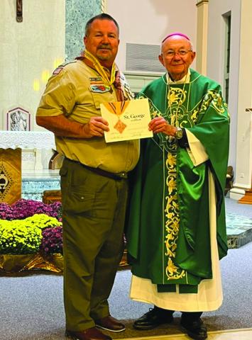 Brian Thompson of Basile (left) receives the St. George medal and certificate from Bishop Douglas Deshotel of the Diocese of Lafayette.