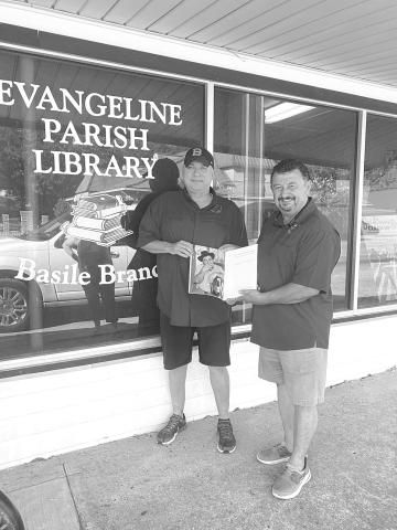 Ben Fontenot (left) and Greg Brown present a copy of Cajun and Creole Music Makers to the Basile branch of the Evangeline Parish Library.