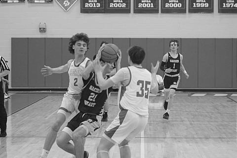 William Jorden (21) looks to get rid of the basketball while being defended by two Central Private players in Sacred Heart’s 57-43 loss in the first round of the Division IV Select playoffs. (Gazette photo by Tony Marks)