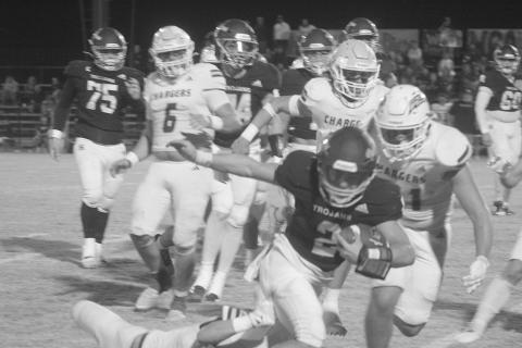 Sacred Heart quarterback Ellis Fusilier (2) stays on his feet as he fights for additional yards in the Trojans’ first-round playoff loss to Westminster Christian Academy of Lafayette last Friday night. (Gazette photo by Tony Marks)